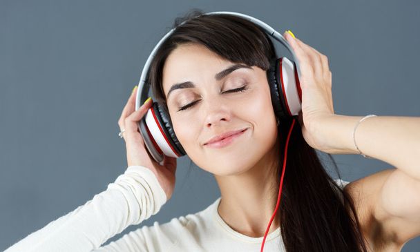 piękne ciemne włosy kobieta uśmiechający się noszenie słuchawek - Zdjęcie, obraz