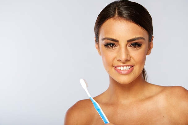 Woman with great teeth holding tooth-brush - Photo, image