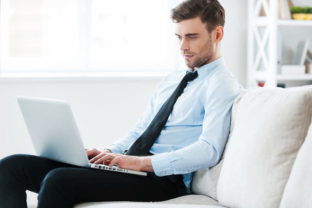 businessman working on laptop while sitting on sofa - Foto, imagen