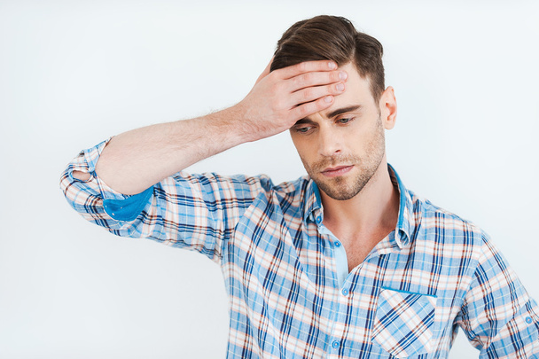Frustrated young man in shirt touching forehead - Foto, afbeelding