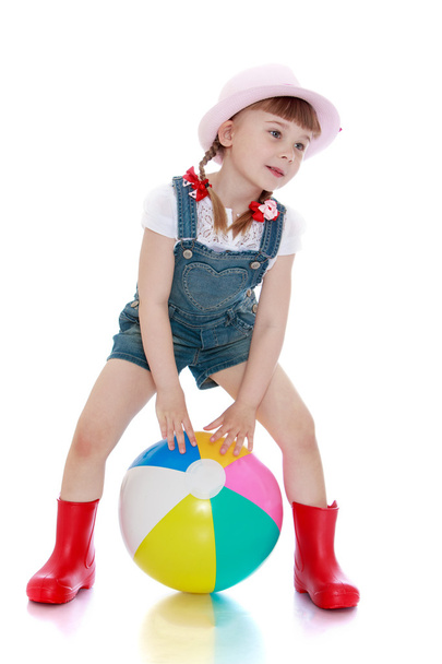 girl in a short denim overalls, hat and rubber boots - Фото, изображение