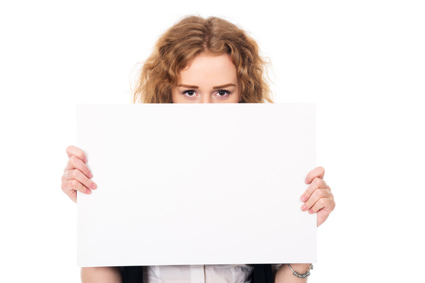 Mujer joven mira sobre una pantalla promocional en blanco aislado en un
  - Foto, imagen