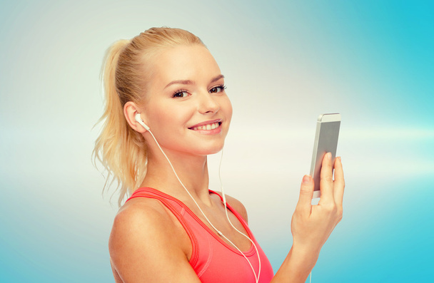 smiling sporty woman with smartphone and earphones - Zdjęcie, obraz