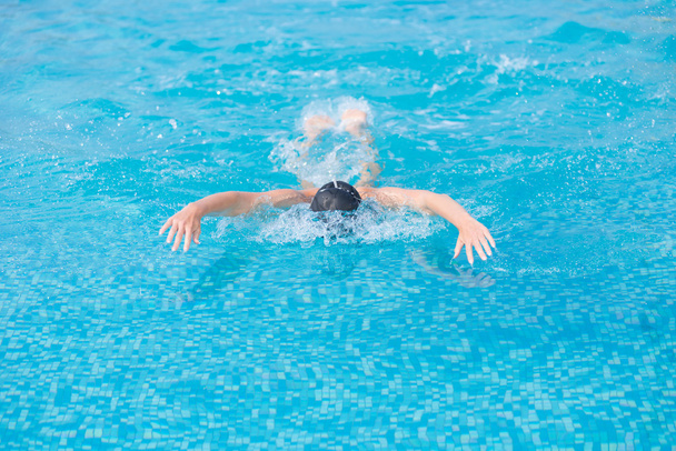 Young girl swimming butterfly stroke style - Fotó, kép