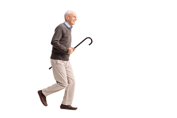 Joyful senior carrying a cane and running  - Foto, Imagem