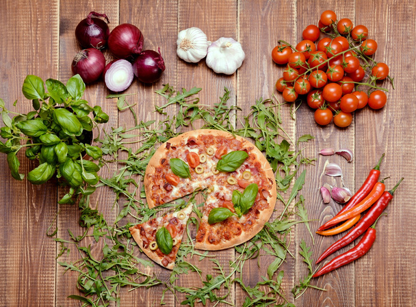 Deliciosa pizza italiana servida sobre mesa de madera
. - Foto, Imagen