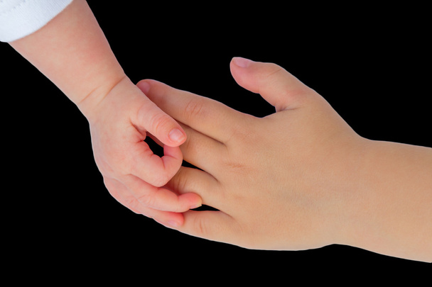 Hand of baby touching hand of child - Photo, Image