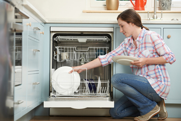 Woman Loading Dishwasher In Kitchen - Foto, Bild