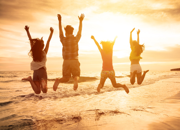 groupe de jeunes gens heureux sautant sur la plage - Photo, image