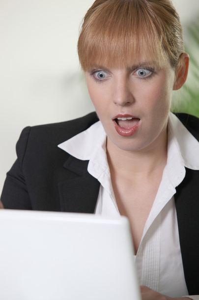 Shocked woman looking at laptop - Фото, изображение
