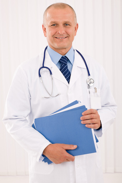 Mature doctor male portrait with folders - Photo, Image