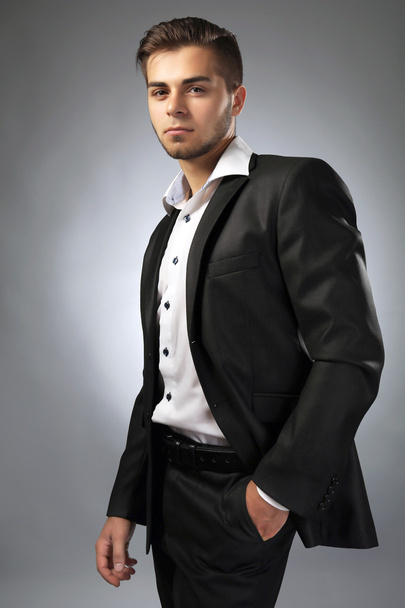 Handsome businessman on gray background - Photo, image
