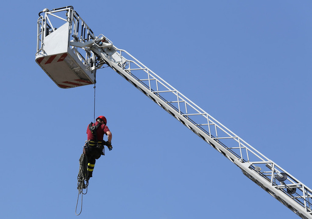Feuerwehrmann mit dem Seilklettern im Feuerwehrhaus - Foto, Bild