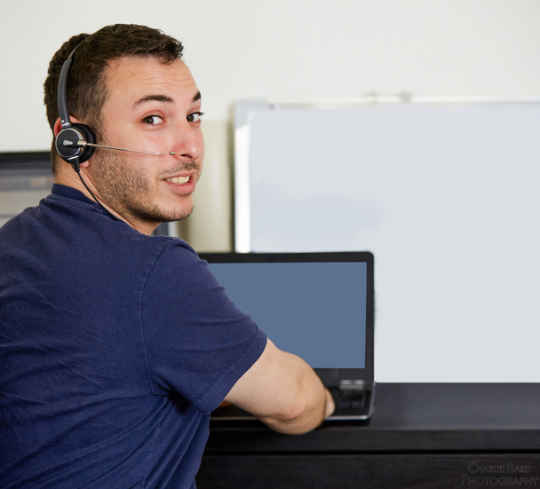 Hombre con el ordenador portátil mirando a la cámara desde la espalda
 - Foto, Imagen