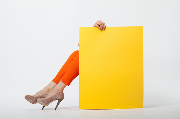 Woman holding yellow paper - Фото, зображення