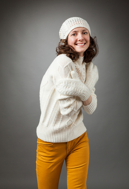 Smiling young woman posing in a studio wearing in a sweater and  - Fotoğraf, Görsel