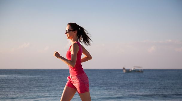 Woman running along the coast - Foto, Bild