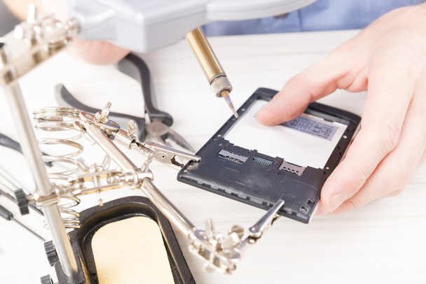 ремонт мобильного телефона в электронном цехе
 - Фото, изображение