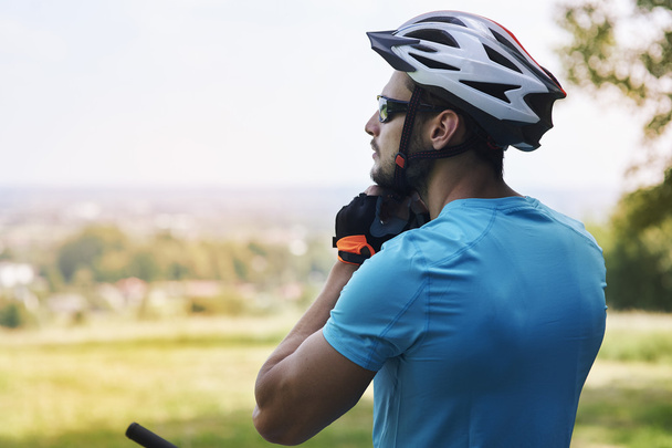 Jeune homme sur le casque de toucher de vélo
 - Photo, image