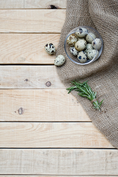 Quail eggs, a bunch of rosemary and burlap - Photo, Image