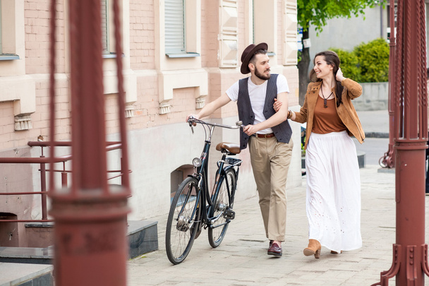 Young couple walking with bicycle and hugging - 写真・画像