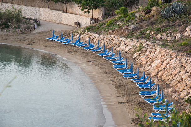 Линия пустых шезлонгов на пляже
 - Фото, изображение