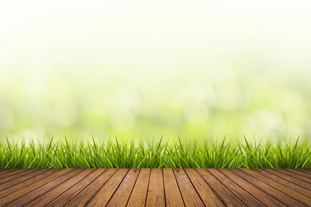 χόρτο με πράσινο φόντο θολή και ξύλινο πάτωμα - Φωτογραφία, εικόνα