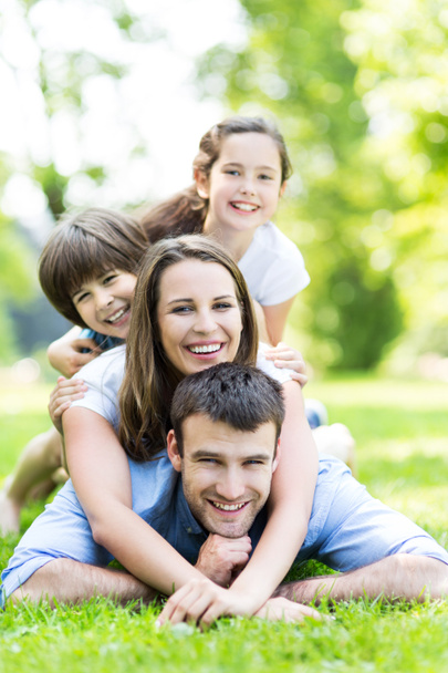 Happy young family lying on grass - Photo, Image