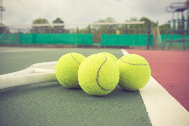 теннисная ракетка и мячи на теннисном корте винтажного цвета
 - Фото, изображение