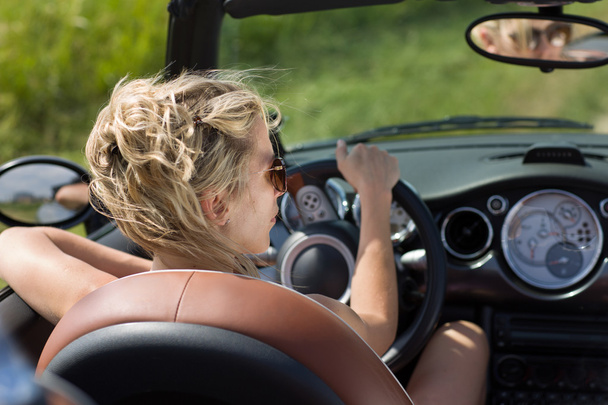 Blonde woman drives cabrio car, in summer sunshine - Zdjęcie, obraz