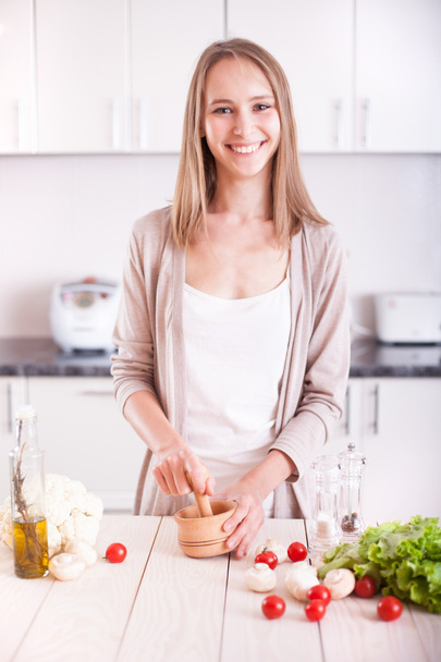 Jeune femme cuisine dans la cuisine - Photo, image