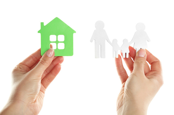 Female hands holding model of house and paper family isolated on white - Φωτογραφία, εικόνα