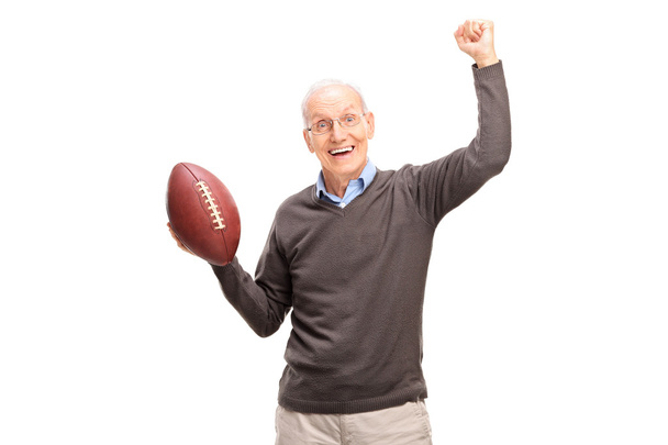 senior man holding an American football - 写真・画像