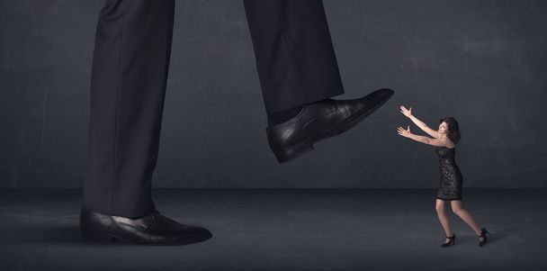 Giant person stepping on a little businesswoman concept - Foto, Imagem