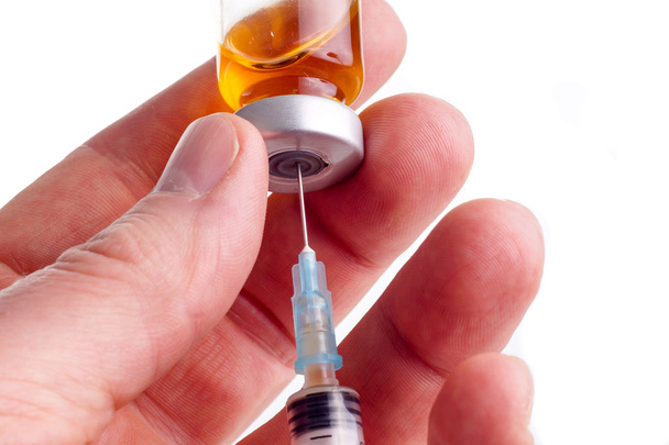 Hand holding syringe and medicine vial  - Photo, Image