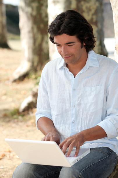 Man in park using laptop - Foto, immagini
