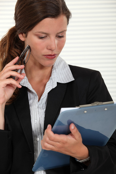 Attractive businesswoman looking down at survey results - Photo, Image