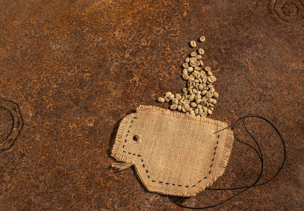 Jüt içinde iğne ve tel çiğ kahve çekirdekleri tam ile dikili bir Kupası paslı masanın üzerine yerleştirilen. - Fotoğraf, Görsel