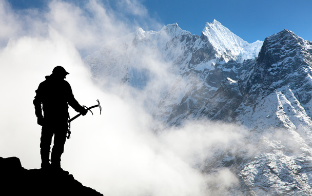 Silhueta de homem com machado de gelo na mão e montanhas
 - Foto, Imagem