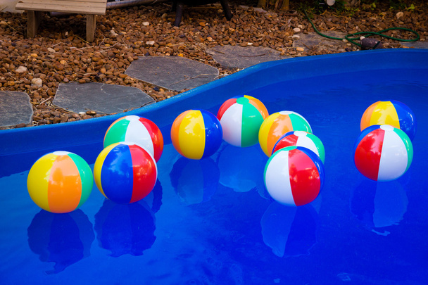 Красочные пляжные шары, плавающие в бассейне
 - Фото, изображение