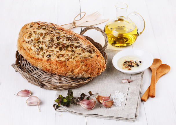 Sourdough bread with seeds, garlic and oil over rustic backgroun - Fotoğraf, Görsel