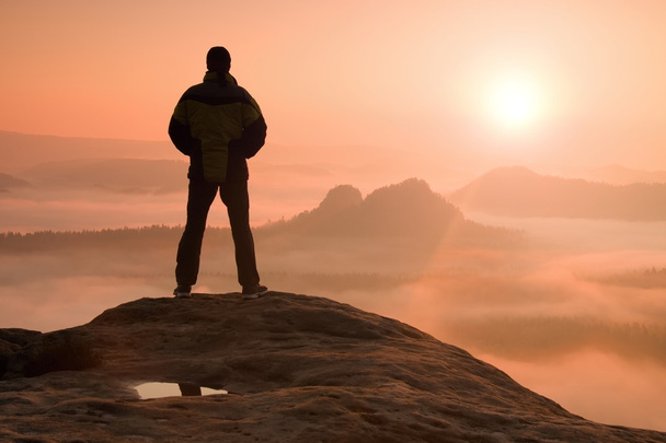 Randonneur seul debout au sommet d'une montagne et profitant du lever du soleil
 - Photo, image