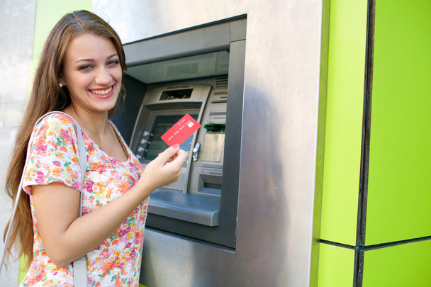 Woman using a cash point machine - Foto, afbeelding
