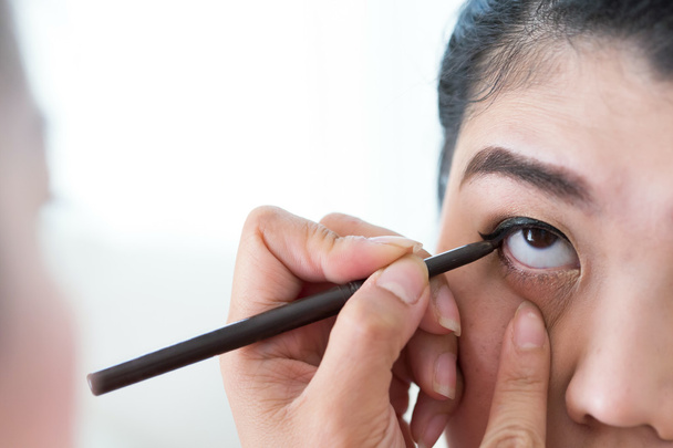 Make-up Schönheit mit Pinsel Eyeliner auf hübsche Frau - Foto, Bild