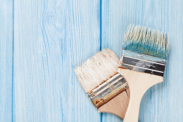 Paintbrush over blue wood - Foto, afbeelding
