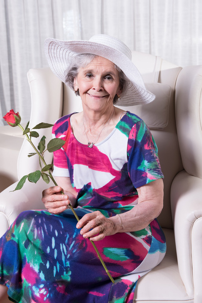 Aktive Seniorin mit Rose in der Hand - Foto, Bild
