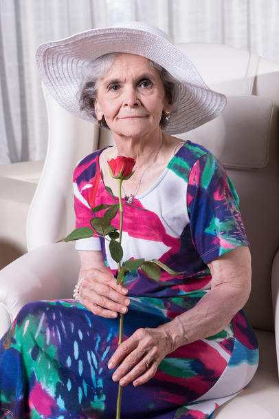 активна жінка старша з трояндою в руці
 - Фото, зображення