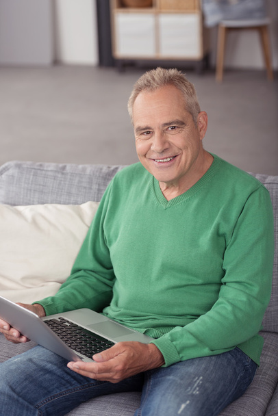 Middle Aged Man with Laptop Sitting on the Couch - Foto, Bild