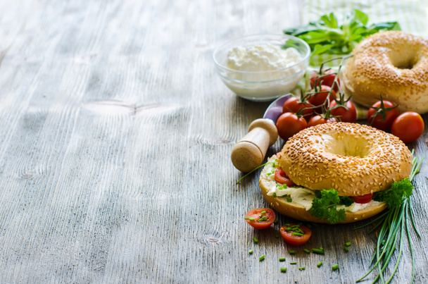 Бублики со сливками, сыр, помидоры и лук для здоровой закуски
 - Фото, изображение