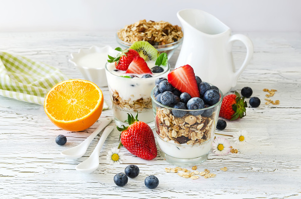 Здоровый завтрак с мюсли в стакане, свежие ягоды и йогурт
 - Фото, изображение